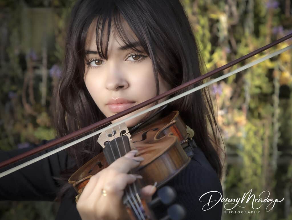 A portrait photograph of a female high school senior playing the violin
